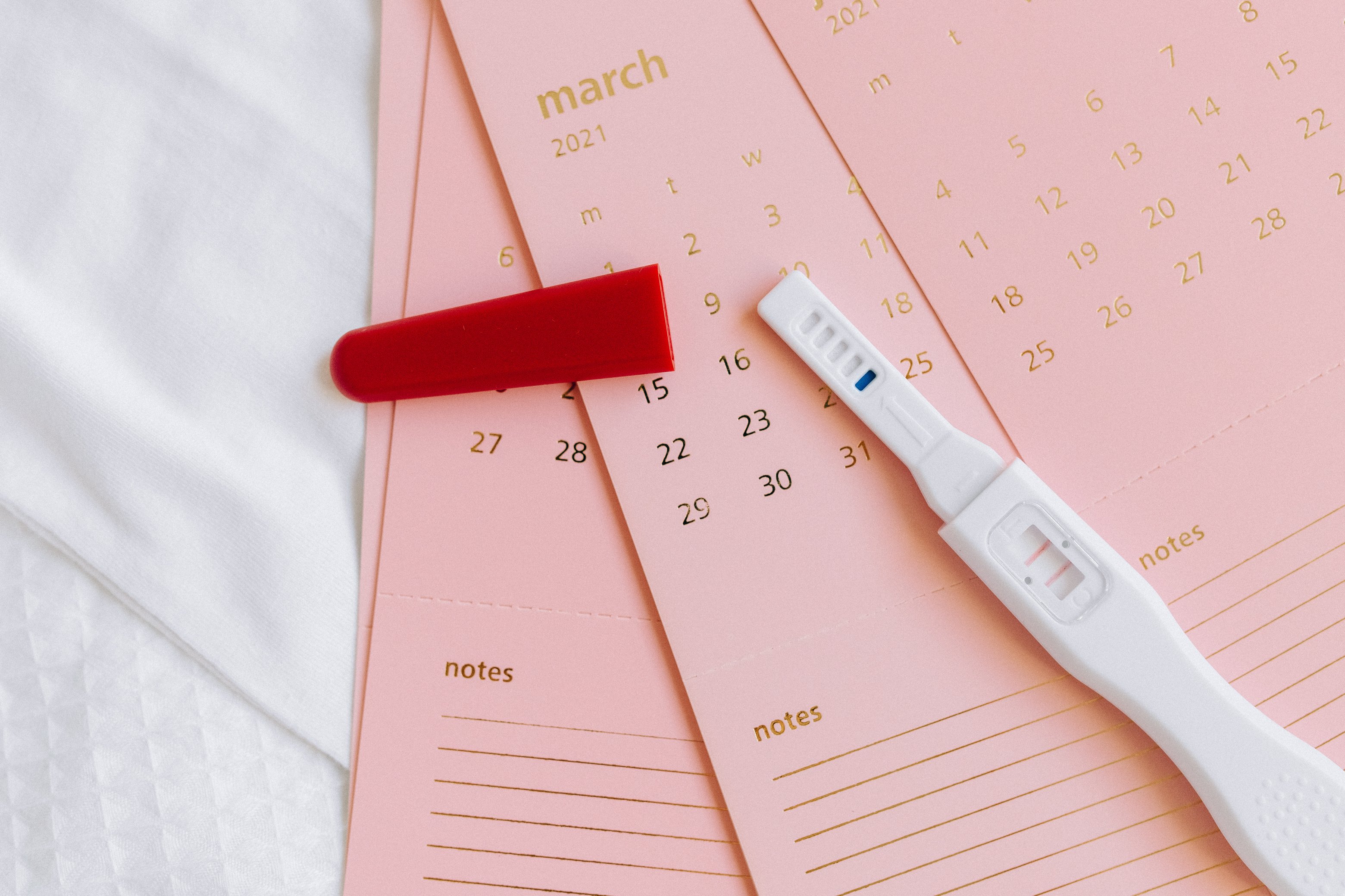White and Red Pregnancy Test on Calendar Cards